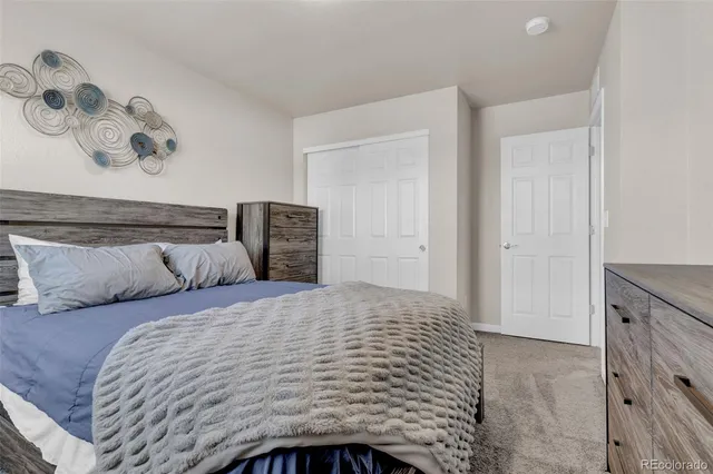 a bedroom with a bed and painting on the wall