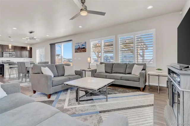 a living room with furniture a flat screen tv and a window