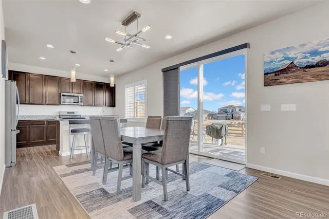a view of a dining room with furniture a kitchen and chandelier