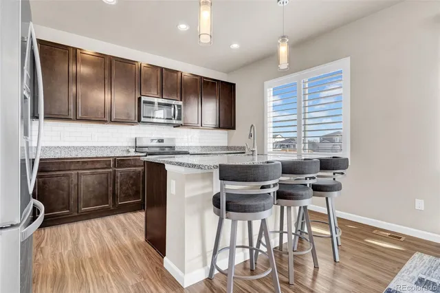 a kitchen with stainless steel appliances granite countertop wooden cabinets a stove top oven a sink and dishwasher