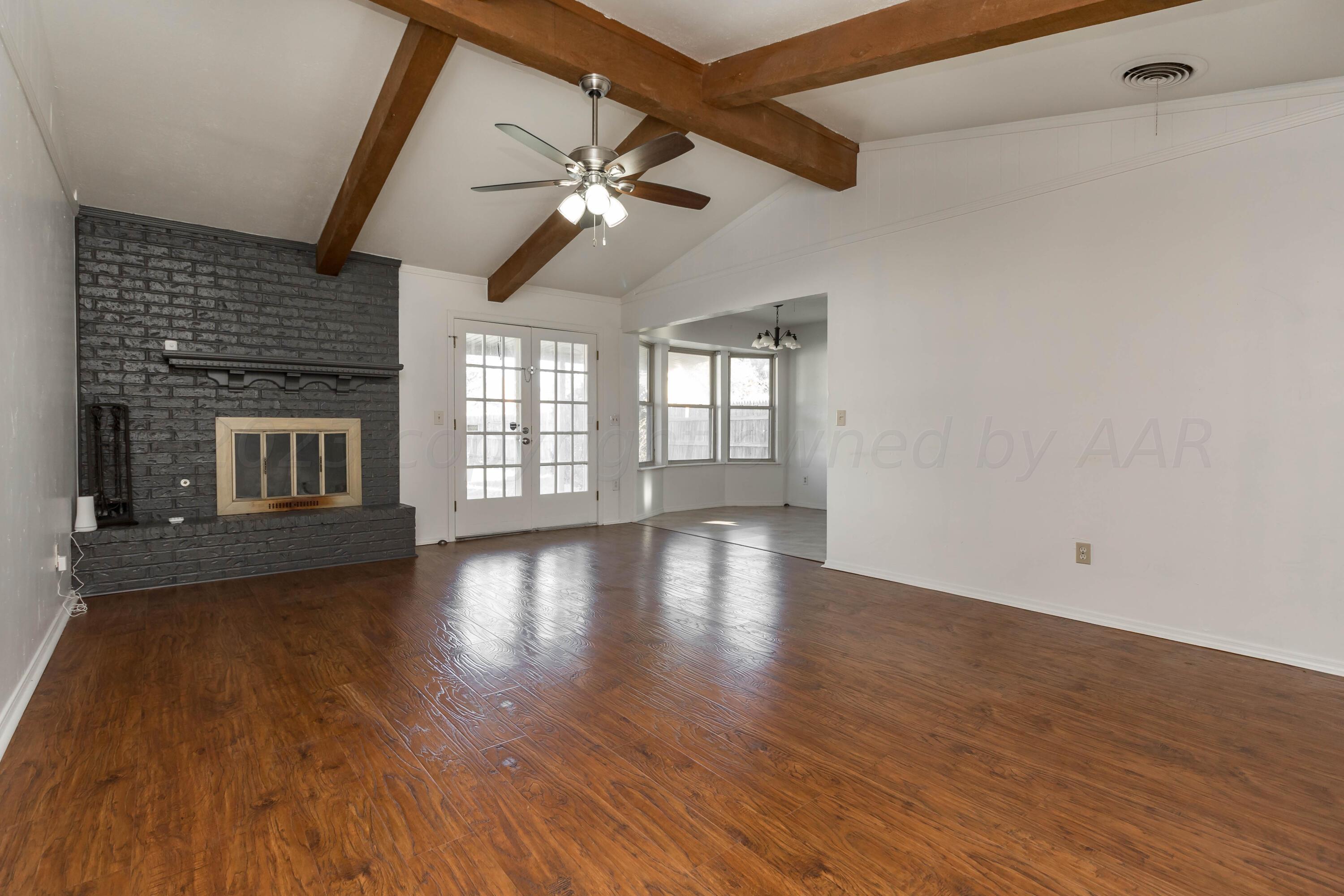 8204 Santa Fe Trail Amarillo, TX 79110 - Photo 2 of 13 a view of an empty room with wooden floor fireplace and a window