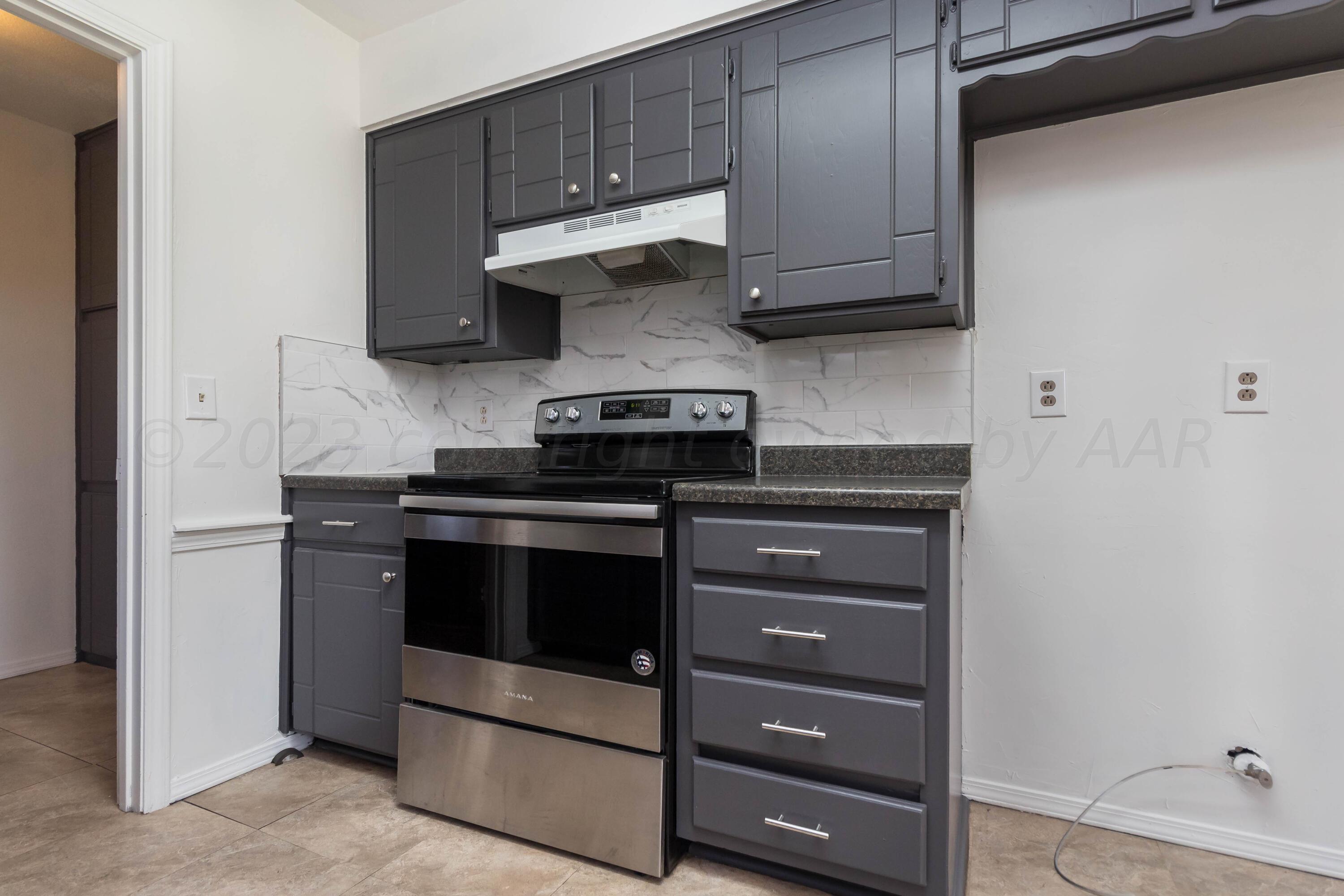 8204 Santa Fe Trail Amarillo, TX 79110 - Photo 4 of 13 a kitchen with wooden cabinets and a stove top oven