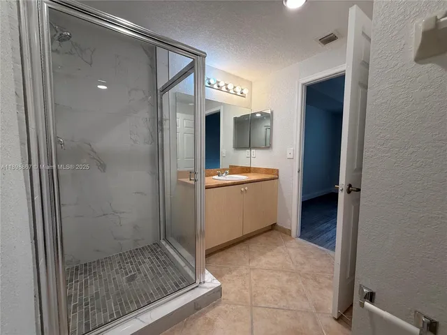 a bathroom with a shower a sink and a mirror