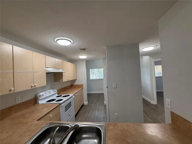 a kitchen with granite countertop a stove and a sink