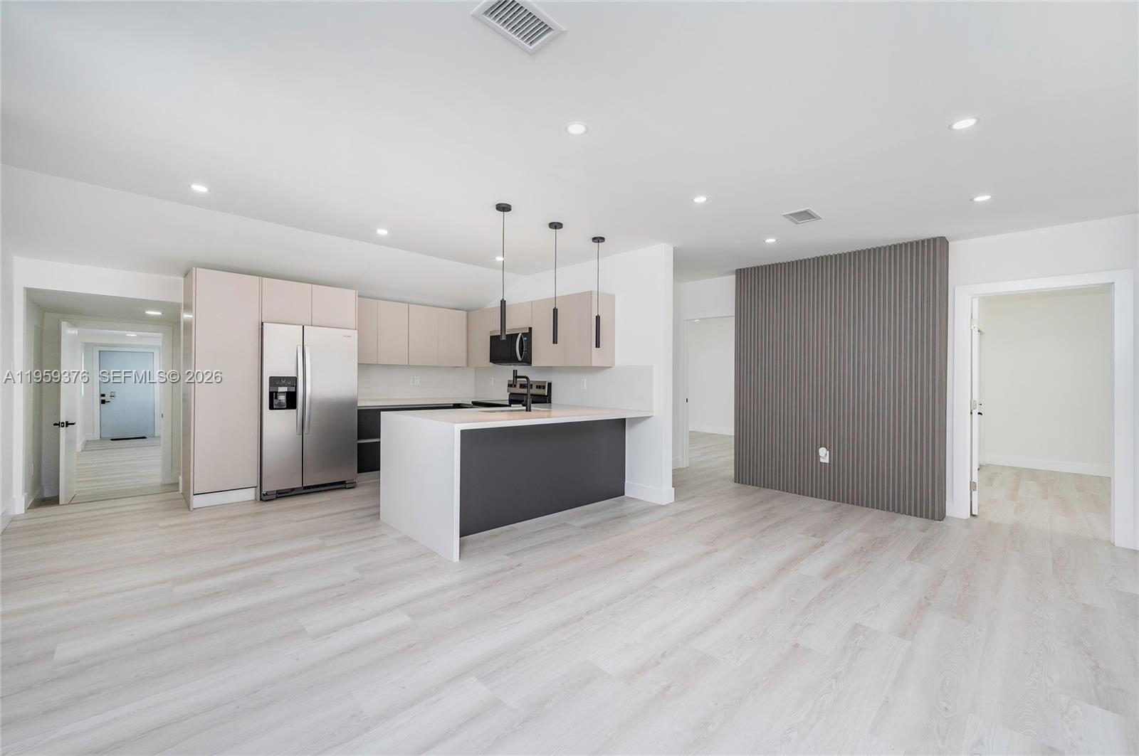 2363 Southwest 11th Terrace Miami, FL 33135 - Photo 13 of 49 a large white kitchen with kitchen island a sink stainless steel appliances and cabinets