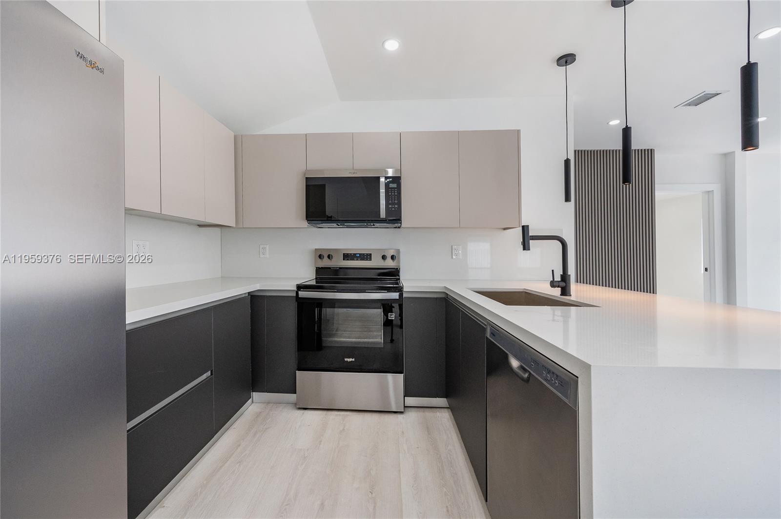 2363 Southwest 11th Terrace Miami, FL 33135 - Photo 16 of 49 a kitchen with stainless steel appliances a sink microwave and stove