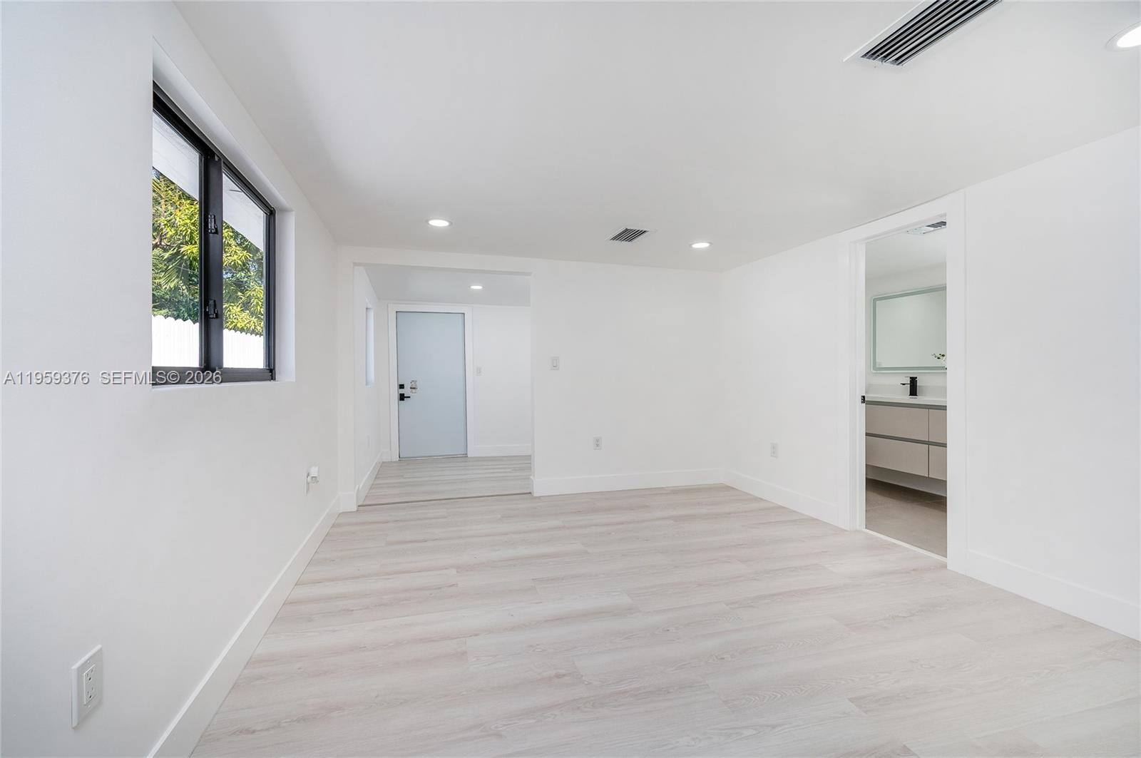 2363 Southwest 11th Terrace Miami, FL 33135 - Photo 22 of 49 wooden floor in an empty room with a window