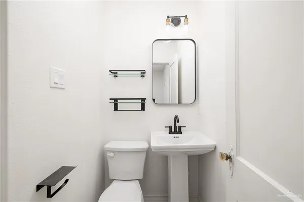 a bathroom with a toilet sink and mirror