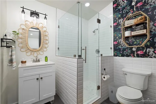 a bathroom with a sink a toilet and shower