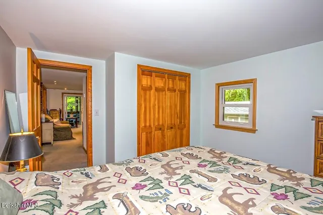 a bedroom with natural light and wooden floor