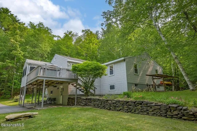 a view of a house with backyard and a tree