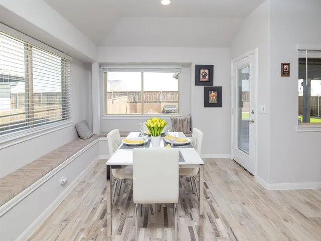 a dining room with furniture and wooden floor