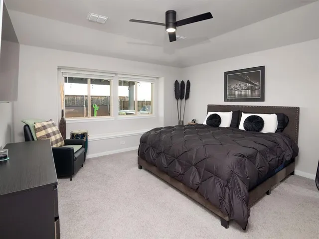 a bedroom with a large bed and windows