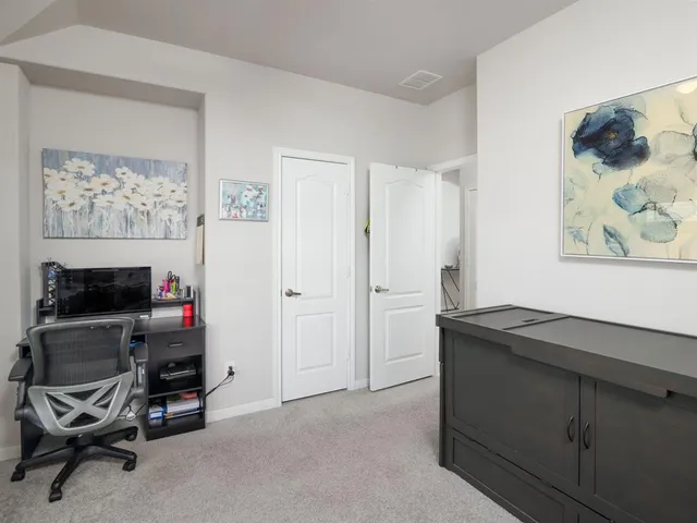 a view of a workspace with furniture and a window