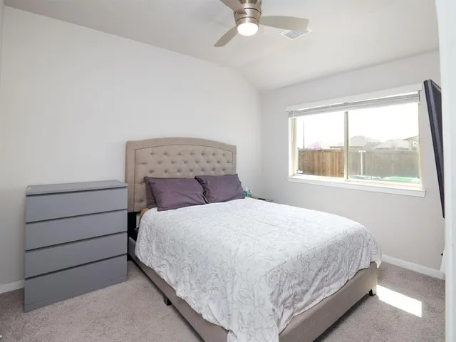 a large bed sitting in a bedroom next to a window