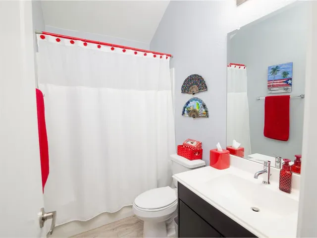 a bathroom with a sink vanity mirror and toilet