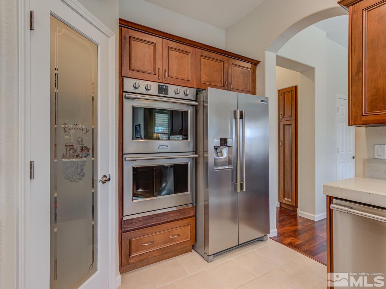 5837 North White Sands Road Reno, NV 89511 - Photo 6 of 22 a kitchen with stainless steel appliances granite countertop a refrigerator and a stove top oven
