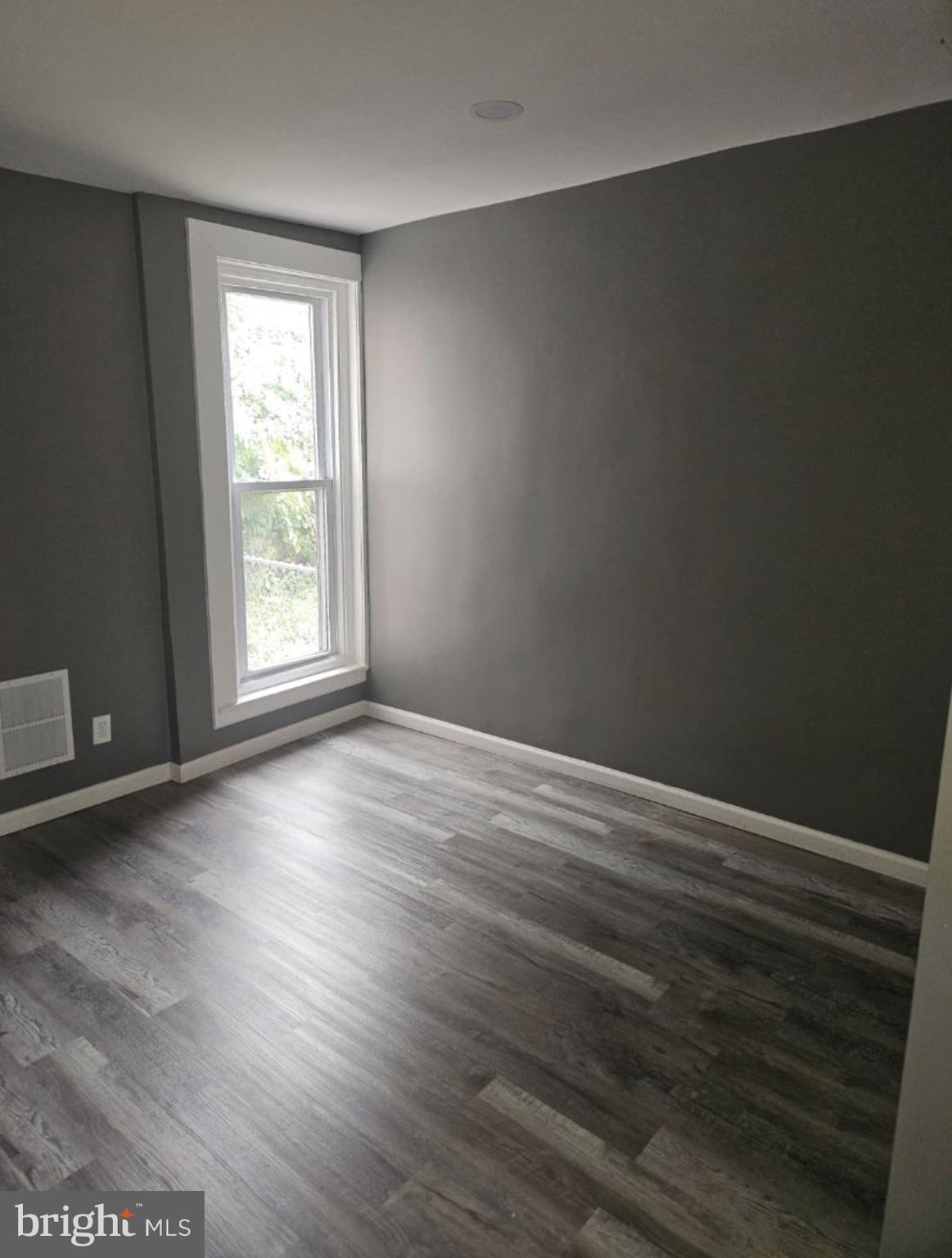 5554 Crowson Street Philadelphia, PA 19144 - Photo 3 of 11 an empty room with wooden floor and windows