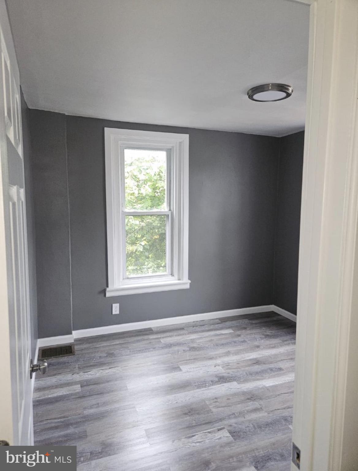 5554 Crowson Street Philadelphia, PA 19144 - Photo 6 of 11 a view of an empty room with wooden floor and a window