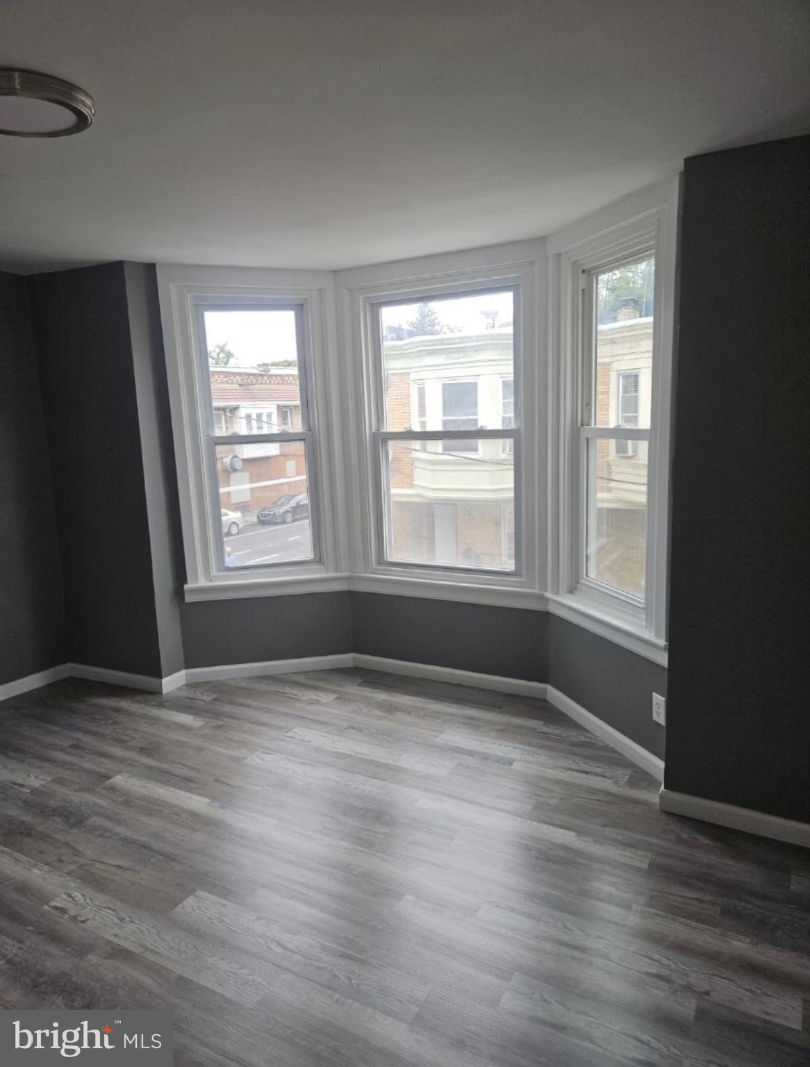 5554 Crowson Street Philadelphia, PA 19144 - Photo 7 of 11 a view of an empty room with wooden floor and a window