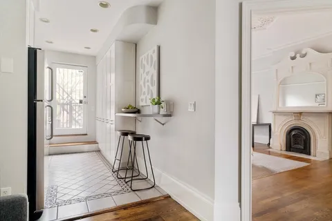 a view of a livingroom with furniture wooden floor a fireplace and windows