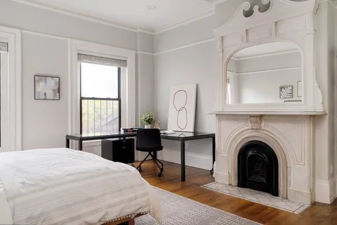 a bedroom with a bed and a fireplace