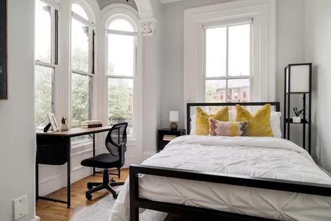 a bedroom with a bed and windows