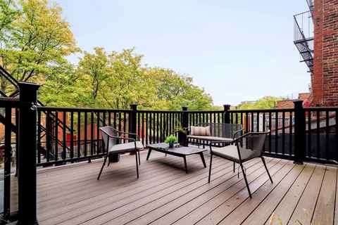 a view of a balcony with wooden floor and bench