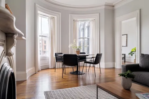 a living room with fireplace furniture and a wooden floor