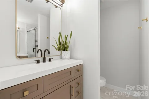 a bathroom with a sink a toilet and mirror