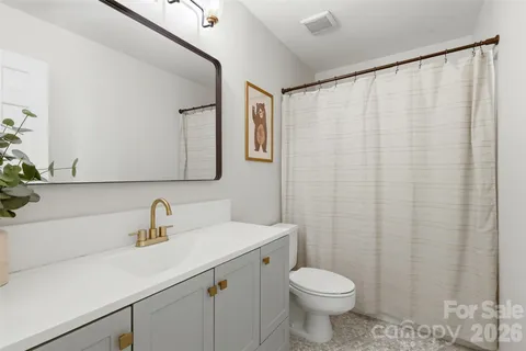 a bathroom with a sink a toilet and a mirror