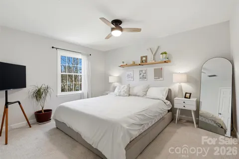 a spacious bedroom with a bed and a flat screen tv