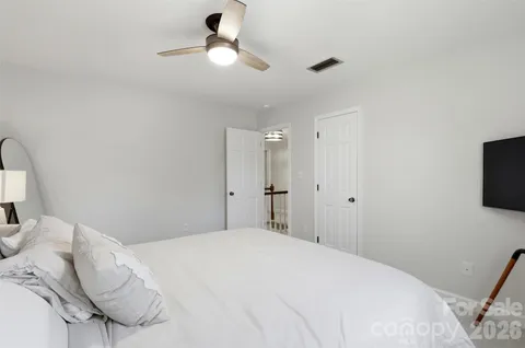 a bedroom with a bed and a flat tv screen on the dresser