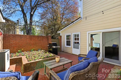 a view of a patio with couches table and chairs under an umbrella