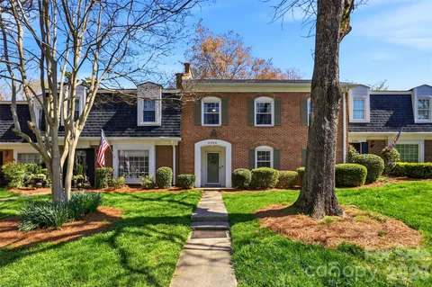 a front view of a house with yard and green space