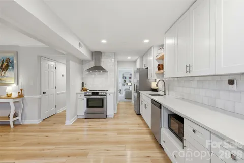 a large kitchen with stainless steel appliances granite countertop a stove and a sink