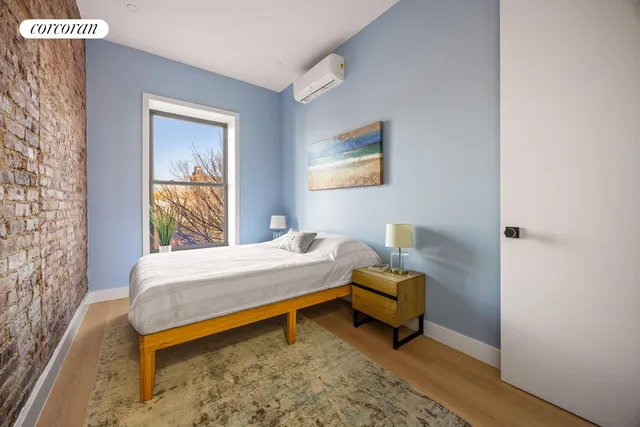 a bedroom with a bed and next to a window