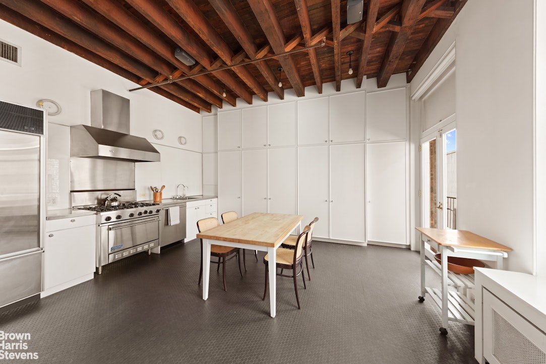 41 Greene Street, Unit 5 Manhattan, NY 10013 - Photo 8 of 10 a kitchen with cabinets and chairs