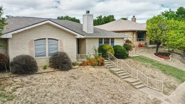 a front view of a house with garden and plants