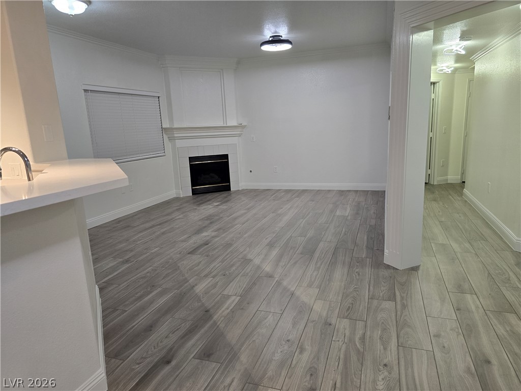 1881 West Alexander Road, Unit 1127 North Las Vegas, NV 89032 - Photo 8 of 20 A refined living area boasts a sleek fireplace, wood-look tile flooring, and clean, architectural lines.
