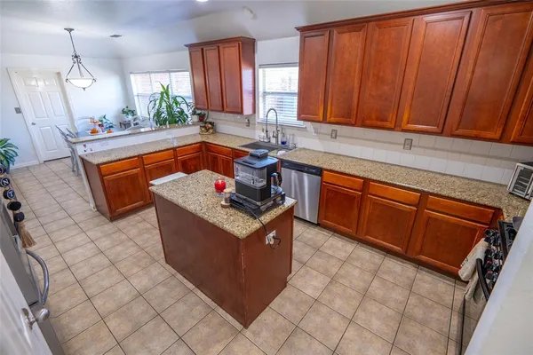 a kitchen with stainless steel appliances granite countertop a sink stove and cabinets