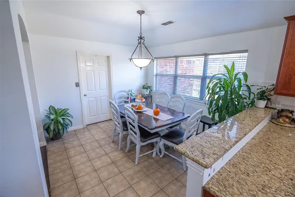a dining room with furniture a potted plant and a rug
