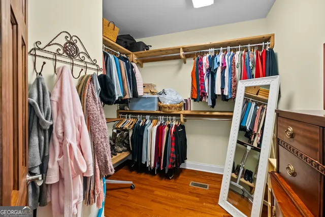 a view of walk in closet with clothes and shoes