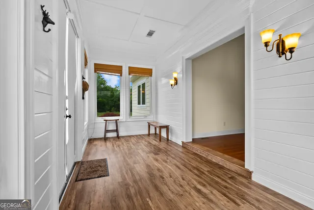 a view of a livingroom with wooden floor and a ceiling fan