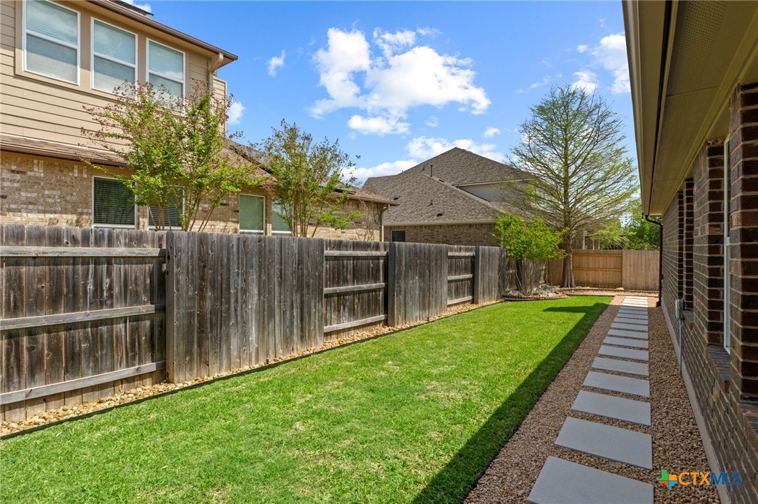 20525 Jackies Ranch Boulevard Pflugerville, TX 78660 - Photo 26 of 30 View of fenced backyard and custom walkway just outside the back door of garage