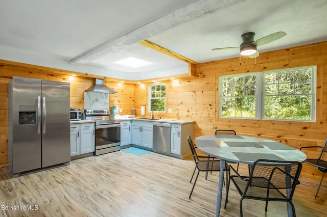 a kitchen with a table chairs sink and refrigerator