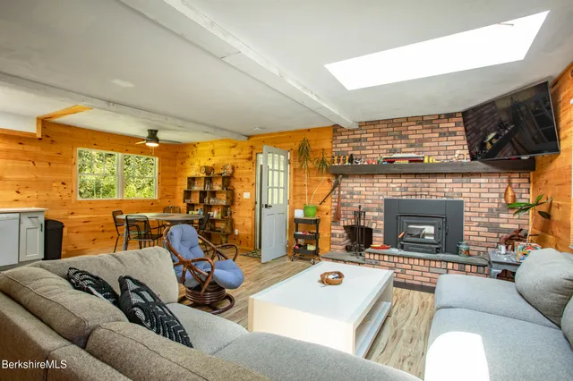 a living room with furniture a fireplace and floor to ceiling window