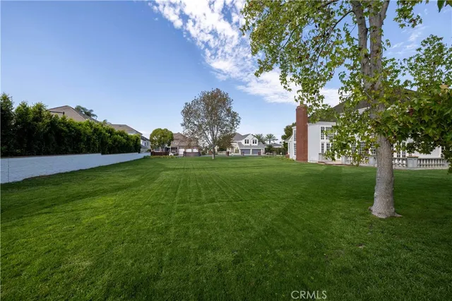 a view of grassy field with benches and trees all around