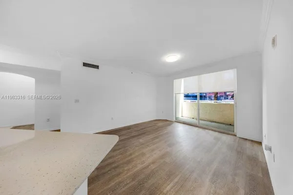 a view of empty room with wooden floor