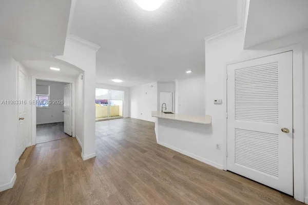 a view of a hallway with wooden floor and a cabinet